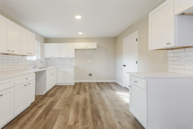 3343 Norcross Ln, Dallas, TX 75229 - kitchen featuring a sink, light wood finished floors, recessed lighting, tasteful backsplash, and white cabinets