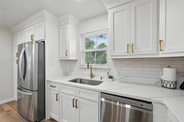 9690 Fallbrook Dr, Dallas, TX 75243 - kitchen featuring appliances with stainless steel finishes, a sink, white cabinetry, and light wood-style floors