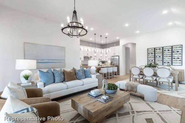 11749 Edgewood Dr, Justin, TX 76247 - living room featuring light wood-style floors, a chandelier, arched walkways, recessed lighting, and a high ceiling