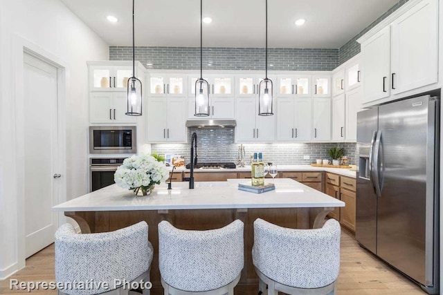 11749 Edgewood Dr, Justin, TX 76247 - kitchen with stainless steel appliances, light countertops, light wood-style floors, tasteful backsplash, and recessed lighting