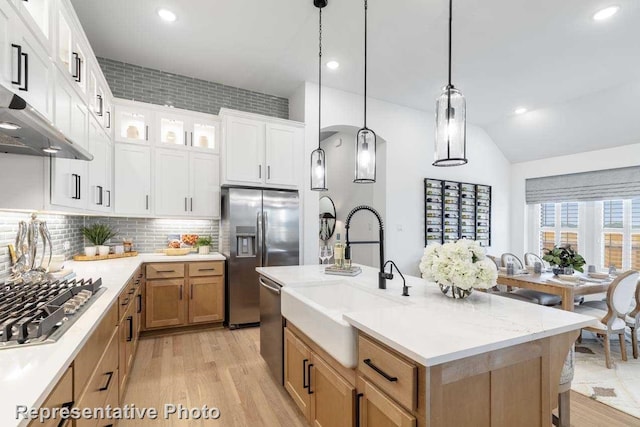 11749 Edgewood Dr, Justin, TX 76247 - kitchen with appliances with stainless steel finishes, a sink, light wood-style flooring, decorative backsplash, and decorative light fixtures