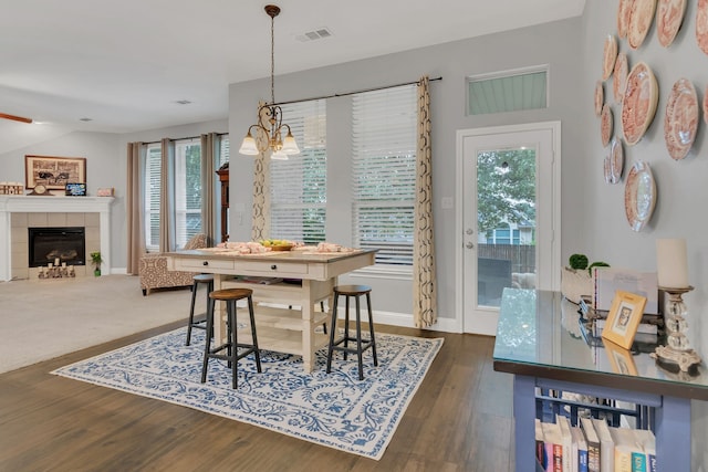 6504 Bluebird Dr, Arlington, TX 76001 - dining room featuring a chandelier, plenty of natural light, wood finished floors, and a fireplace