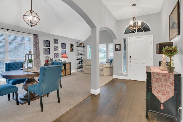 6504 Bluebird Dr, Arlington, TX 76001 - foyer featuring a chandelier, arched walkways, dark wood-style floors, baseboards, and high vaulted ceiling