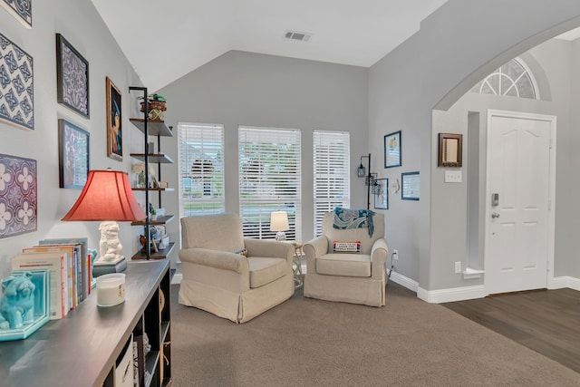 6504 Bluebird Dr, Arlington, TX 76001 - living area featuring vaulted ceiling, baseboards, carpet floors, arched walkways, and wood finished floors