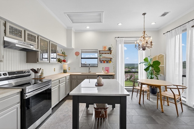 616 Crowley Rd, Arlington, TX 76012 - kitchen with stainless steel electric stove, under cabinet range hood, a sink, open shelves, and plenty of natural light