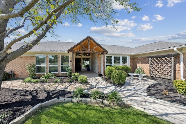 7101 Odell Ave, Rockwall, TX 75087 - view of front of property with brick siding, an attached garage, a shingled roof, and a patio area