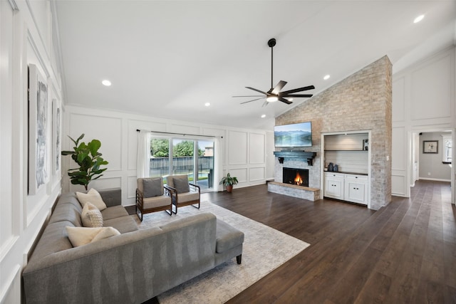 7101 Odell Ave, Rockwall, TX 75087 - living area with a decorative wall, vaulted ceiling, ceiling fan, a brick fireplace, and dark wood finished floors