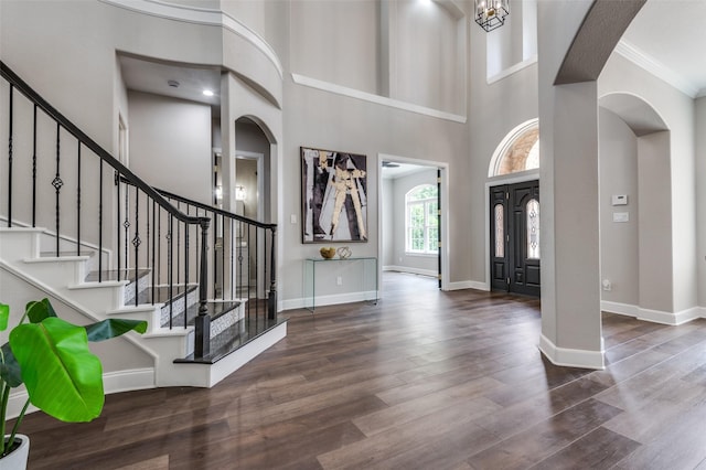 2007 Hill Country Ct, Arlington, TX 76012 - foyer entrance featuring arched walkways, wood finished floors, stairs, a high ceiling, and baseboards
