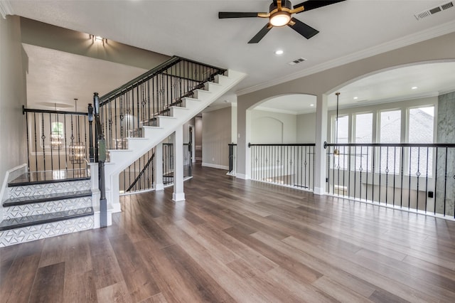 2007 Hill Country Ct, Arlington, TX 76012 - unfurnished living room featuring a ceiling fan, wood finished floors, baseboards, arched walkways, and crown molding