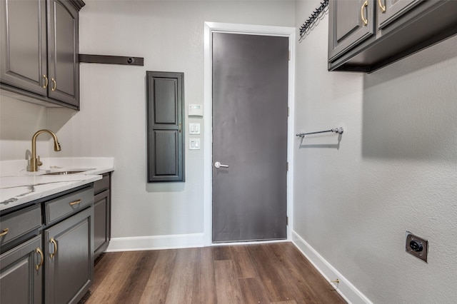 2007 Hill Country Ct, Arlington, TX 76012 - laundry room featuring baseboards, electric dryer hookup, dark wood-type flooring, and cabinet space