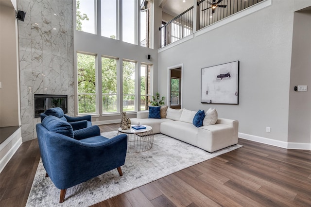 2007 Hill Country Ct, Arlington, TX 76012 - living room featuring baseboards, a towering ceiling, wood finished floors, a high end fireplace, and a ceiling fan
