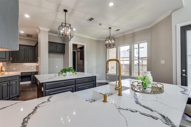 2007 Hill Country Ct, Arlington, TX 76012 - kitchen featuring backsplash, a chandelier, crown molding, dark wood-style floors, and light stone countertops