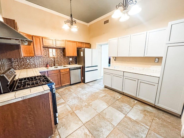 211 W Saunders St, Trenton, TX 75490 - kitchen with stainless steel appliances, ornamental molding, a towering ceiling, a chandelier, and decorative backsplash