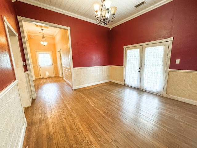 211 W Saunders St, Trenton, TX 75490 - empty room with a chandelier, wood-type flooring, wainscoting, crown molding, and french doors