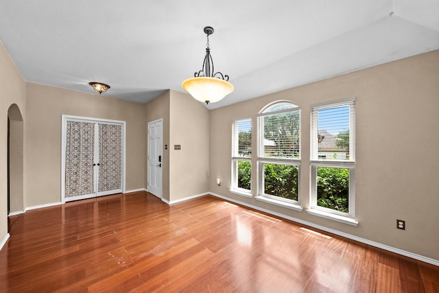 741 Oak Dale Ave, Lake Dallas, TX 75065 - unfurnished room with arched walkways, baseboards, and wood finished floors