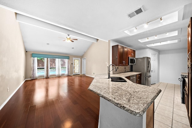 741 Oak Dale Ave, Lake Dallas, TX 75065 - kitchen with a sink, stainless steel appliances, open floor plan, light stone countertops, and baseboards