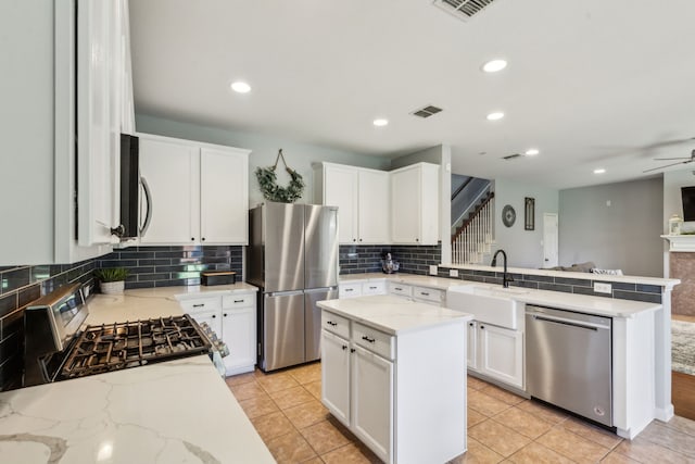 5708 Pebble Ridge Dr, Mckinney, TX 75070 - kitchen with stainless steel appliances, a sink, a peninsula, backsplash, and light stone countertops