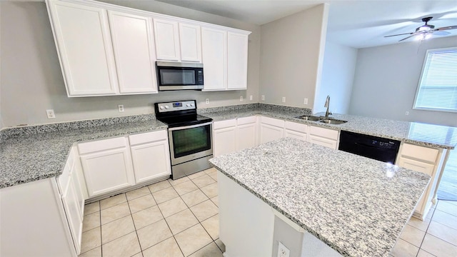4110 Sandalwood Ct, Forney, TX 75126 - kitchen featuring appliances with stainless steel finishes, a sink, light tile patterned flooring, a peninsula, and a kitchen island