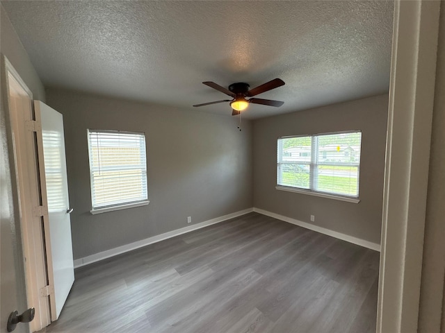 2401 N Alexander St, Sherman, TX 75092 - spare room featuring a textured ceiling, wood finished floors, a ceiling fan, and baseboards