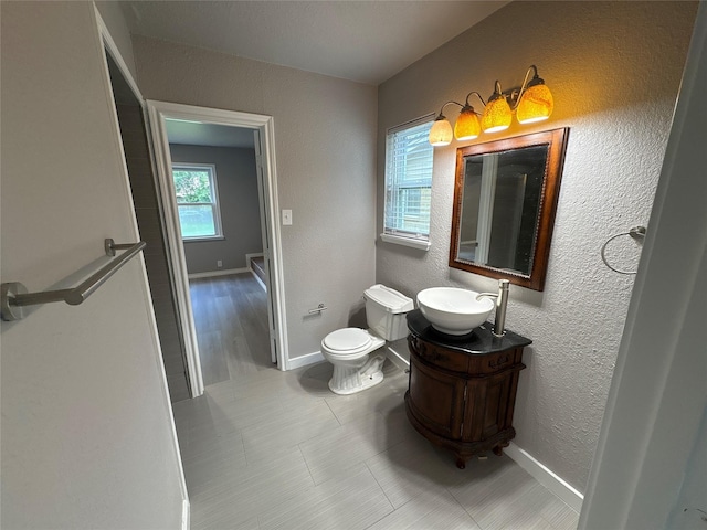 2401 N Alexander St, Sherman, TX 75092 - bathroom with vanity, toilet, baseboards, a textured wall, and tile patterned floors