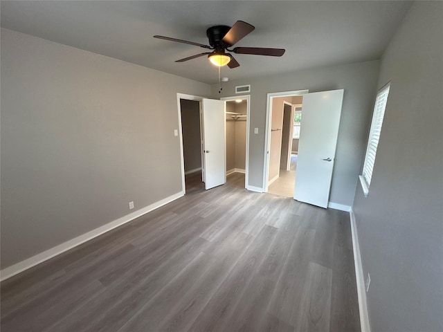 2401 N Alexander St, Sherman, TX 75092 - unfurnished bedroom featuring wood finished floors, baseboards, a ceiling fan, a closet, and a spacious closet