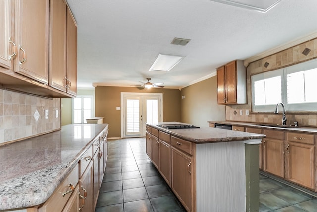 226 Miramar Dr, Arlington, TX 76002 - kitchen with a sink, a center island, black stovetop, decorative backsplash, and tile patterned flooring