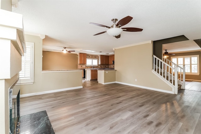 226 Miramar Dr, Arlington, TX 76002 - unfurnished living room with a ceiling fan, stairway, wood finished floors, and crown molding