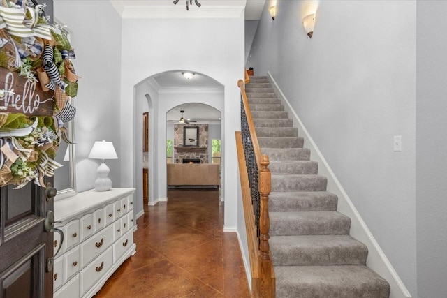 106 Versailles Ln, Aledo, TX 76008 - foyer entrance featuring ornamental molding, a stone fireplace, arched walkways, stairway, and finished concrete flooring