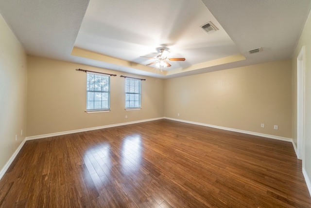 12916 Gillon Dr, Frisco, TX 75035 - empty room with a tray ceiling, a ceiling fan, dark wood-style flooring, and baseboards