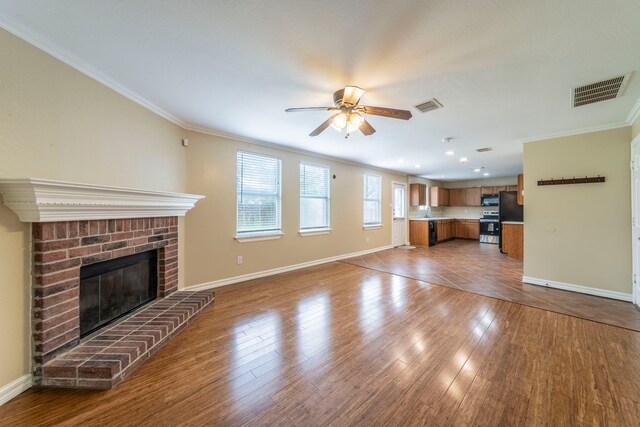 12916 Gillon Dr, Frisco, TX 75035 - unfurnished living room featuring ornamental molding, a ceiling fan, baseboards, a fireplace, and wood finished floors