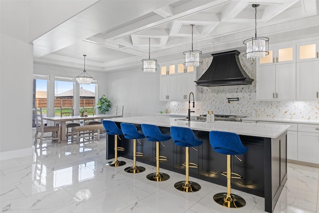 10901 Chriswood Dr, Crowley, TX 76036 - kitchen featuring premium range hood, coffered ceiling, backsplash, a sink, and an island with sink