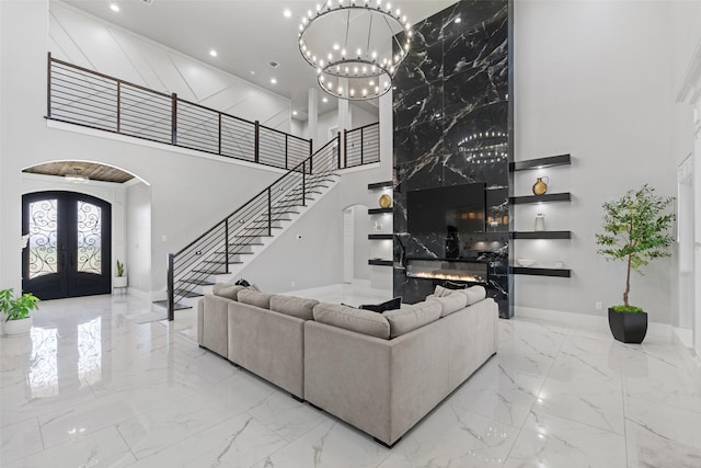 10901 Chriswood Dr, Crowley, TX 76036 - living room with arched walkways, a towering ceiling, marble tiled flooring, french doors, and stairs