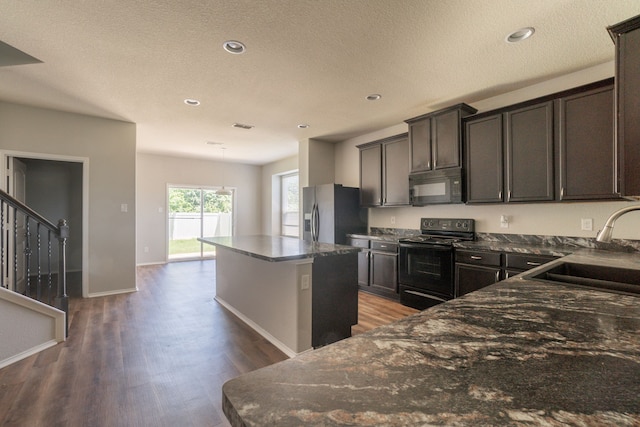 9233 Benevolent Ct, Providence Village, TX 76227 - kitchen featuring black appliances, a sink, a kitchen island, dark wood-type flooring, and recessed lighting
