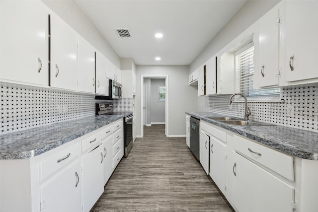 104 W Mistletoe Dr, Kennedale, TX 76060 - kitchen featuring appliances with stainless steel finishes, a sink, backsplash, white cabinets, and recessed lighting