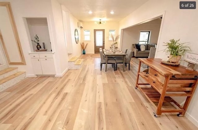 1917 E Mulberry St, Sherman, TX 75090 - dining space featuring light wood-type flooring, a wall mounted AC, baseboards, stairway, and a chandelier