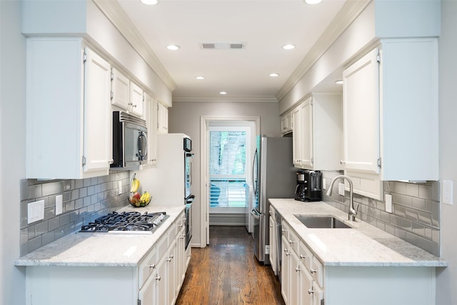 9030 Summer Glen Ln, Dallas, TX 75243 - kitchen with appliances with stainless steel finishes, a sink, crown molding, white cabinetry, and dark wood-style floors