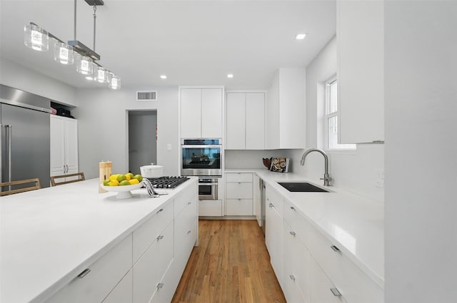 4356 San Carlos St, University Park, TX 75205 - kitchen with a sink, white cabinetry, light wood-style flooring, light countertops, and recessed lighting
