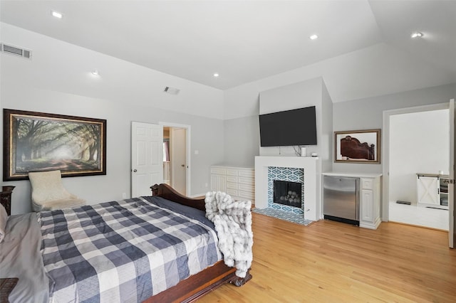 4356 San Carlos St, University Park, TX 75205 - bedroom featuring fridge, light wood finished floors, a fireplace, and recessed lighting