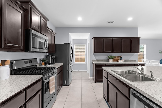 16316 Caledonia Ct, Justin, TX 76247 - kitchen featuring stainless steel appliances, a sink, dark brown cabinets, light countertops, and light tile patterned floors