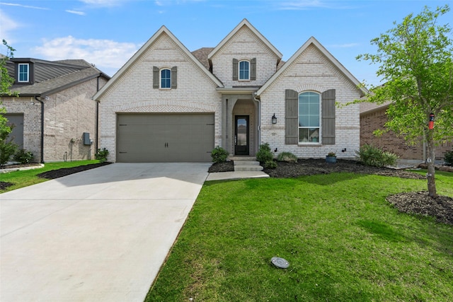 2020 Rhea Ct, Celina, TX 75009 - french provincial home featuring concrete driveway, a front yard, a garage, and brick siding