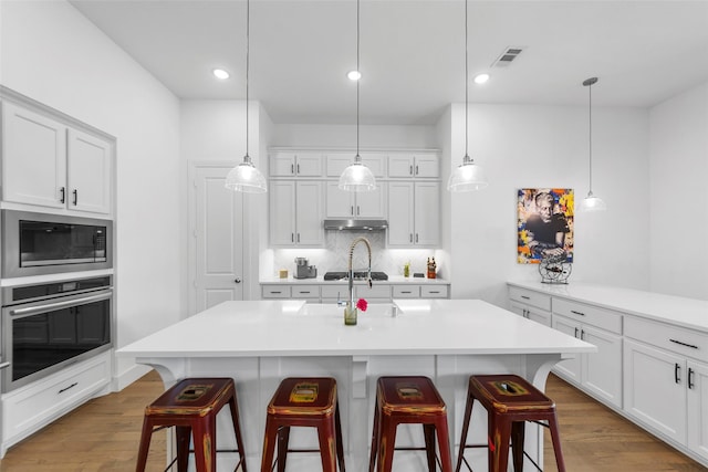 2020 Rhea Ct, Celina, TX 75009 - kitchen featuring stainless steel oven, built in microwave, a kitchen breakfast bar, light countertops, and backsplash