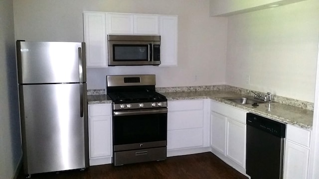2320 W Prairie St, Denton, TX 76201 - kitchen with stainless steel appliances, a sink, white cabinets, dark wood-style floors, and light stone counters
