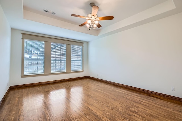 7341 Chadwick Dr, Mckinney, TX 75072 - spare room with a tray ceiling, wood finished floors, a ceiling fan, and baseboards