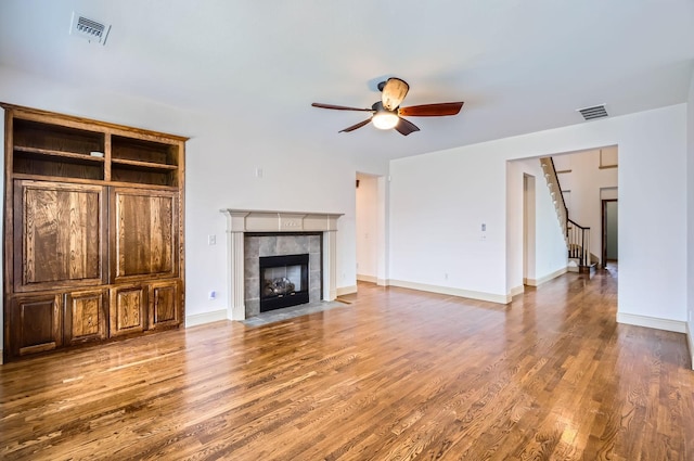 7341 Chadwick Dr, Mckinney, TX 75072 - unfurnished living room featuring ceiling fan, wood finished floors, stairway, a tiled fireplace, and baseboards