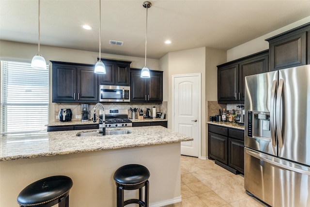 5212 Sugarcane Ln, Fort Worth, TX 76179 - kitchen with stainless steel appliances, backsplash, a sink, a kitchen bar, and recessed lighting