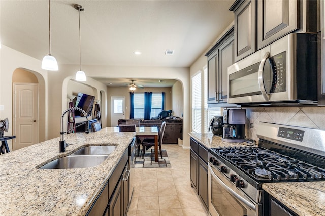 5212 Sugarcane Ln, Fort Worth, TX 76179 - kitchen featuring appliances with stainless steel finishes, a sink, arched walkways, open floor plan, and recessed lighting