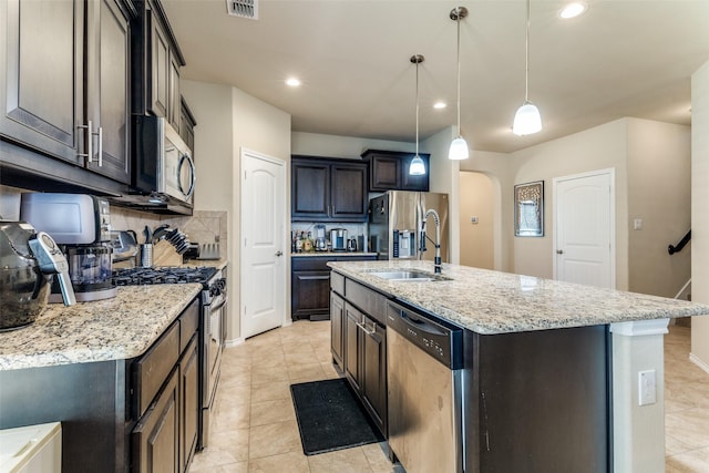 5212 Sugarcane Ln, Fort Worth, TX 76179 - kitchen featuring stainless steel appliances, arched walkways, a sink, tasteful backsplash, and light tile patterned floors