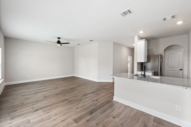 1025 Pecan Pl, Hutchins, TX 75141 - kitchen featuring freestanding refrigerator, a sink, a ceiling fan, white cabinets, and wood finished floors