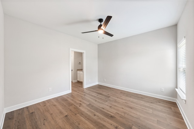 1025 Pecan Pl, Hutchins, TX 75141 - unfurnished bedroom with wood finished floors, baseboards, connected bathroom, and ceiling fan
