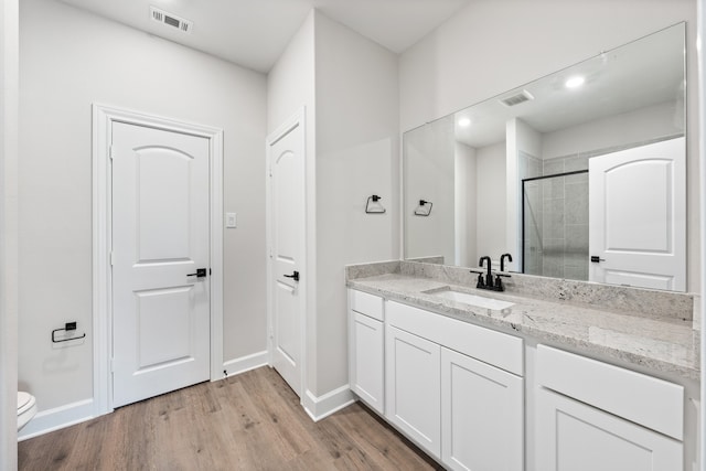 1025 Pecan Pl, Hutchins, TX 75141 - bathroom with vanity, tiled shower, toilet, wood finished floors, and baseboards